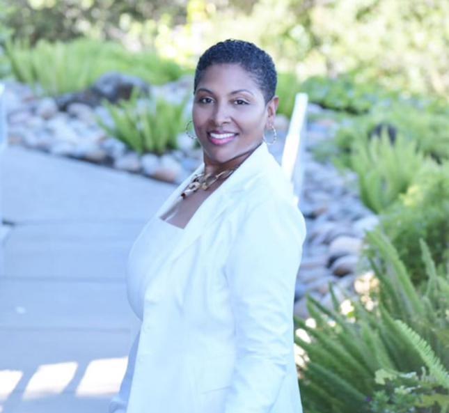 Katrina Carter in a white blazer, smiling outdoors