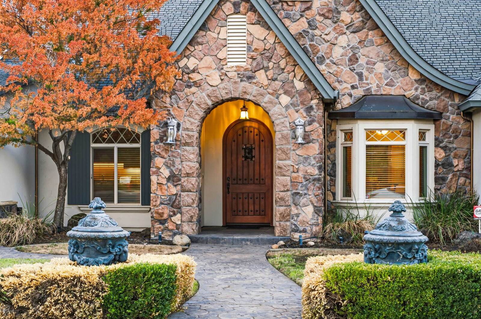 Arched wood front door set in a stone entry